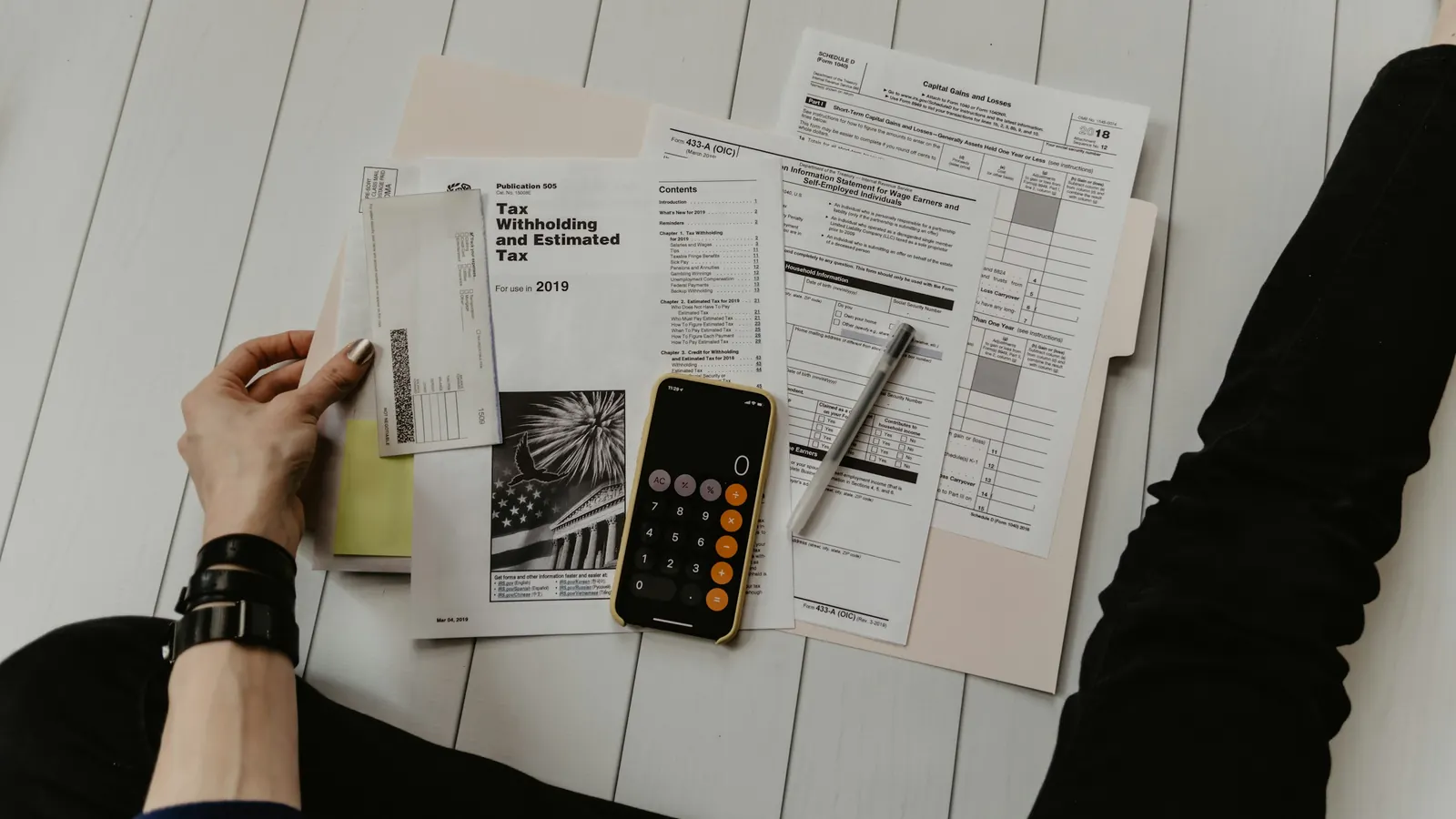 Calculator and paperwork used to compare the total cost of a hotel stay with corporate housing rentals